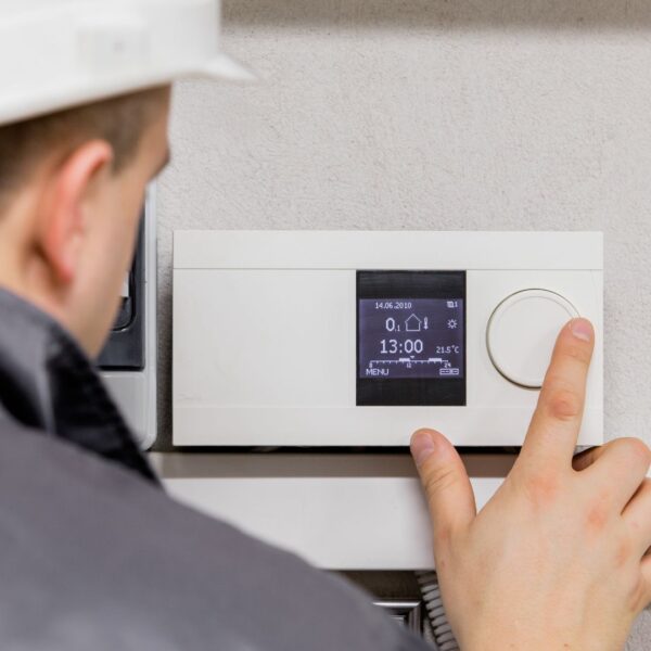 hvac technician using thermostat